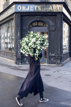 Great Future Ahead is a photo of a girl in the 9th Arrondissement in Paris with a giant bouquet of white lisianthus and is part of a limited edition series named Young Girl in Bloom by photographer Carla Coulson celebrating women loving and believing in themselves and building their self esteem by trusting their intuition.