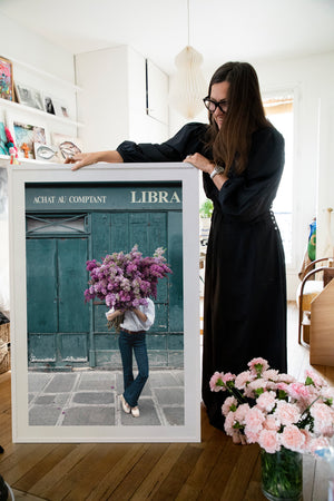 Beauty In Balance is a photo of a girl in St Germain des Prés holding a big bunch of lilacs and is part of a limited edition series named Young Girl in Bloom by photographer Carla Coulson celebrating women loving and believing in themselves and building their self esteem by trusting their intuition.