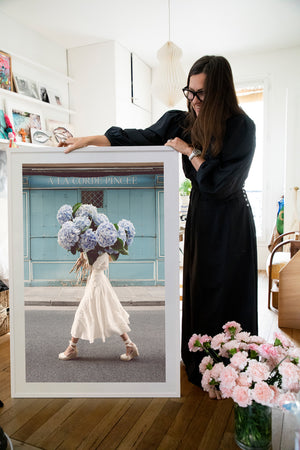 Out Of The Blue is a photo of a girl in Paris in St Germain des Prés holding the biggest bunch of baby blue hydrangeas and is part of a limited edition series named Young Girl in Bloom by photographer Carla Coulson celebrating women loving and believing in themselves and building their self esteem by trusting their intuition.