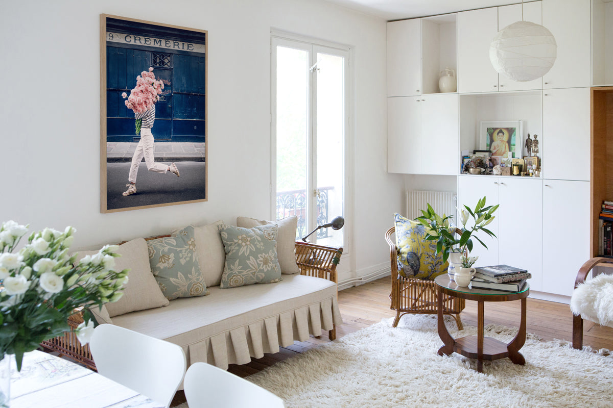Follow Your Bliss is an image of a girl with a huge bouquet of pink carnations in her arms skipping along the street in front of La Crèmerie in the 6th Arrondissement in Paris.